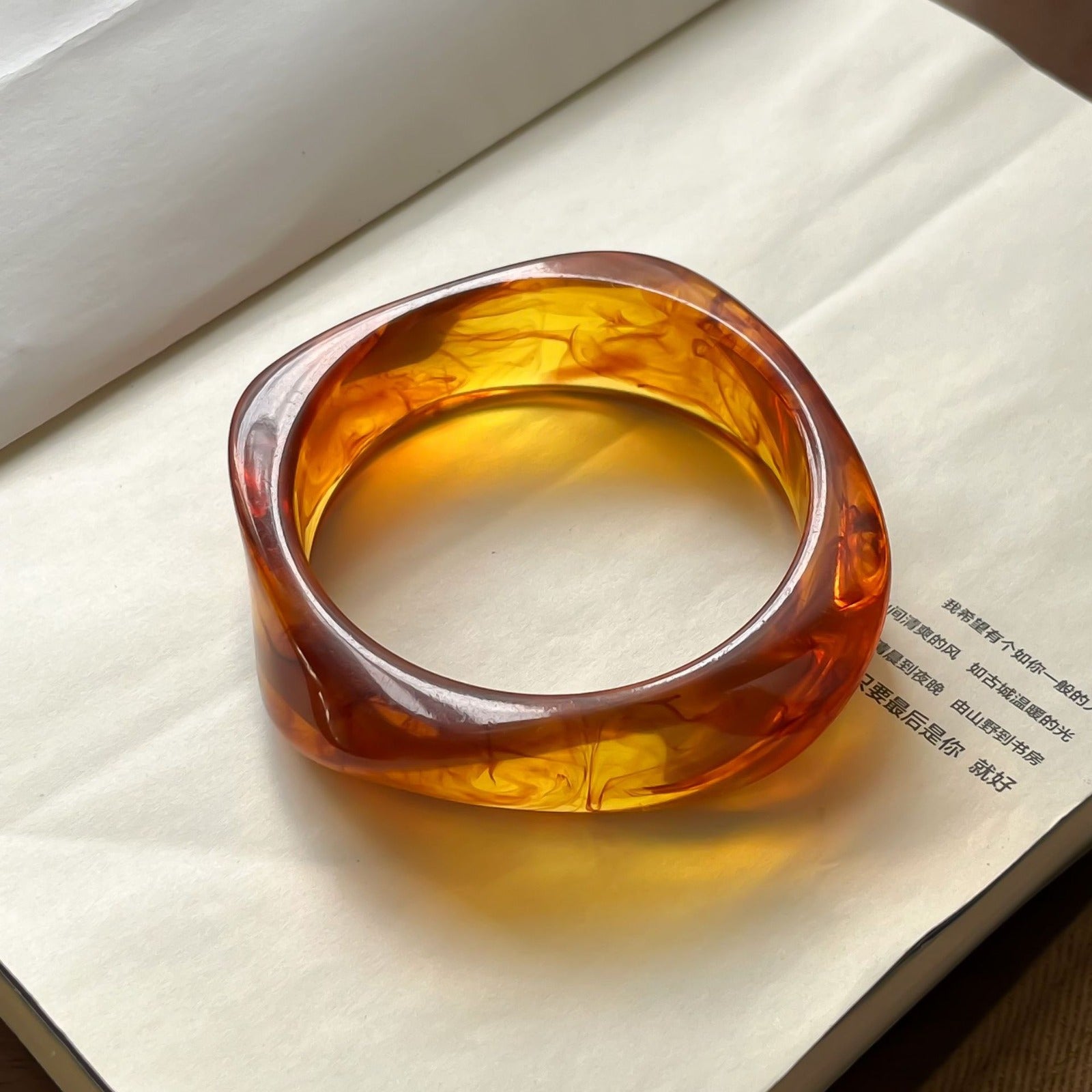 Amber-colored bangle on a textured surface