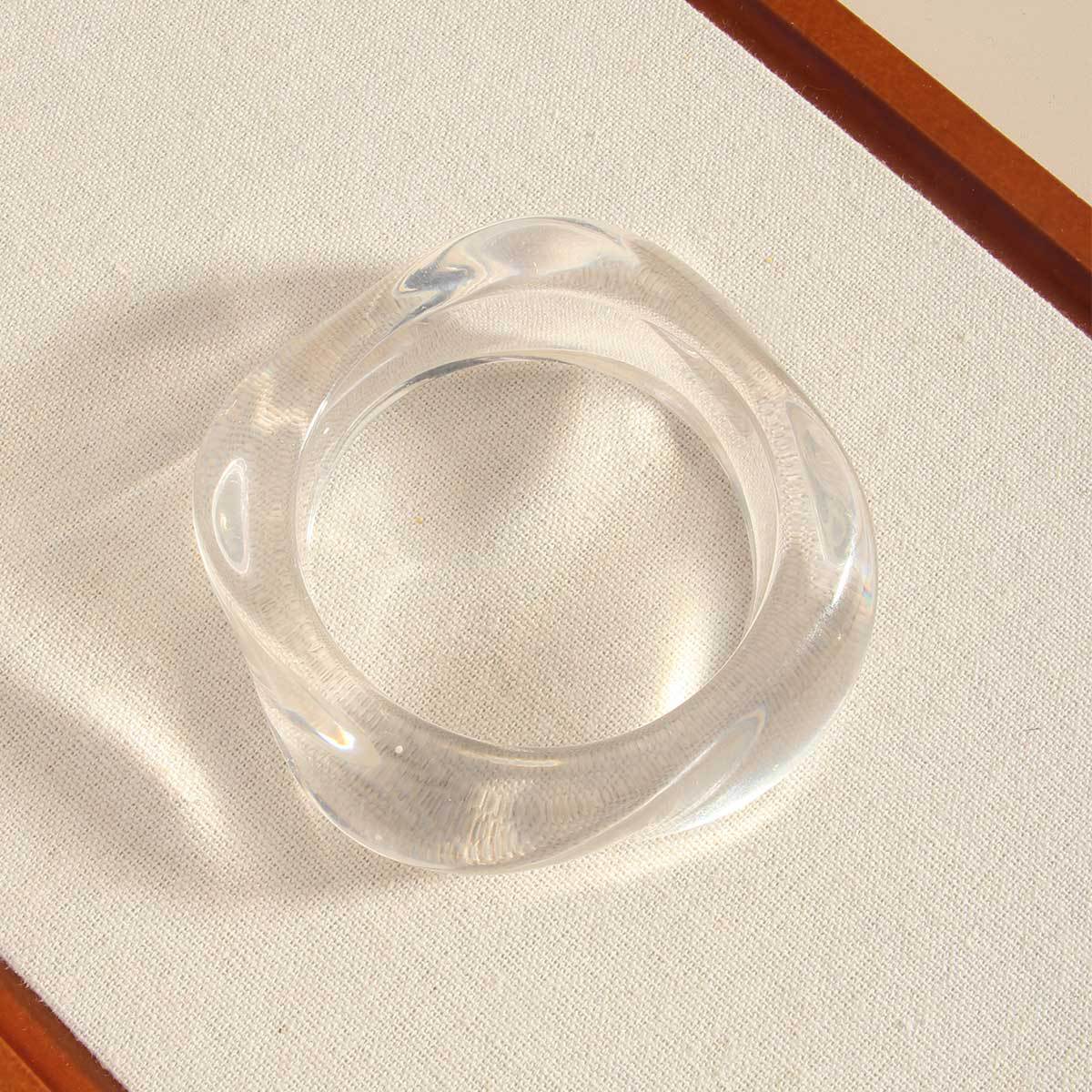 Clear plastic ring on a beige fabric background