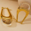 Gold hoop earrings with clear stones on a beige background