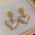 Heart-shaped earrings with gold frames on a white background