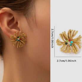 Gold earrings with floral design worn by a person, shown with measurements and weight information.