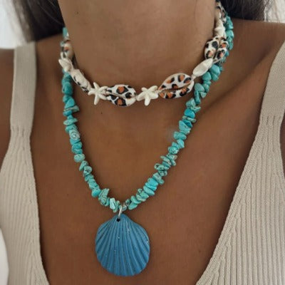 Turquoise necklace with shell pendant worn by a person