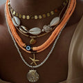 Necklace with shell and starfish pendants on a person's neck