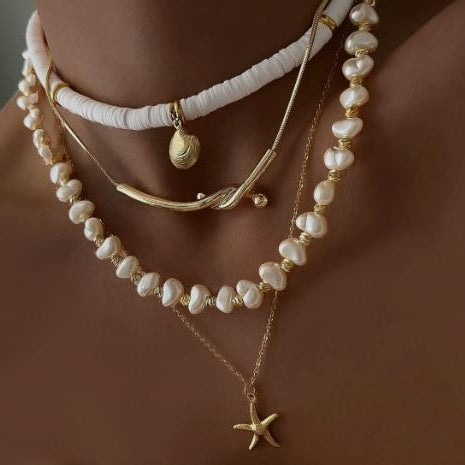 Necklace with starfish pendant and pearl beads on a brown background