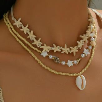 Starfish and shell necklace on a person with a blurred natural background