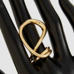 Gold ring on a black mannequin hand against a white background