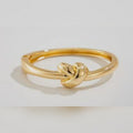 Gold knot ring on a light gray background