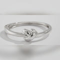 Silver ring with a knot design on a light gray background